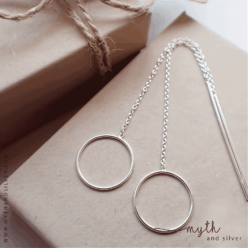 Sterling silver 16 mm circle threader earrings laid on a kraft jewellery box, showing the chains and long posts