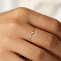 Tiny cz stone ring on person