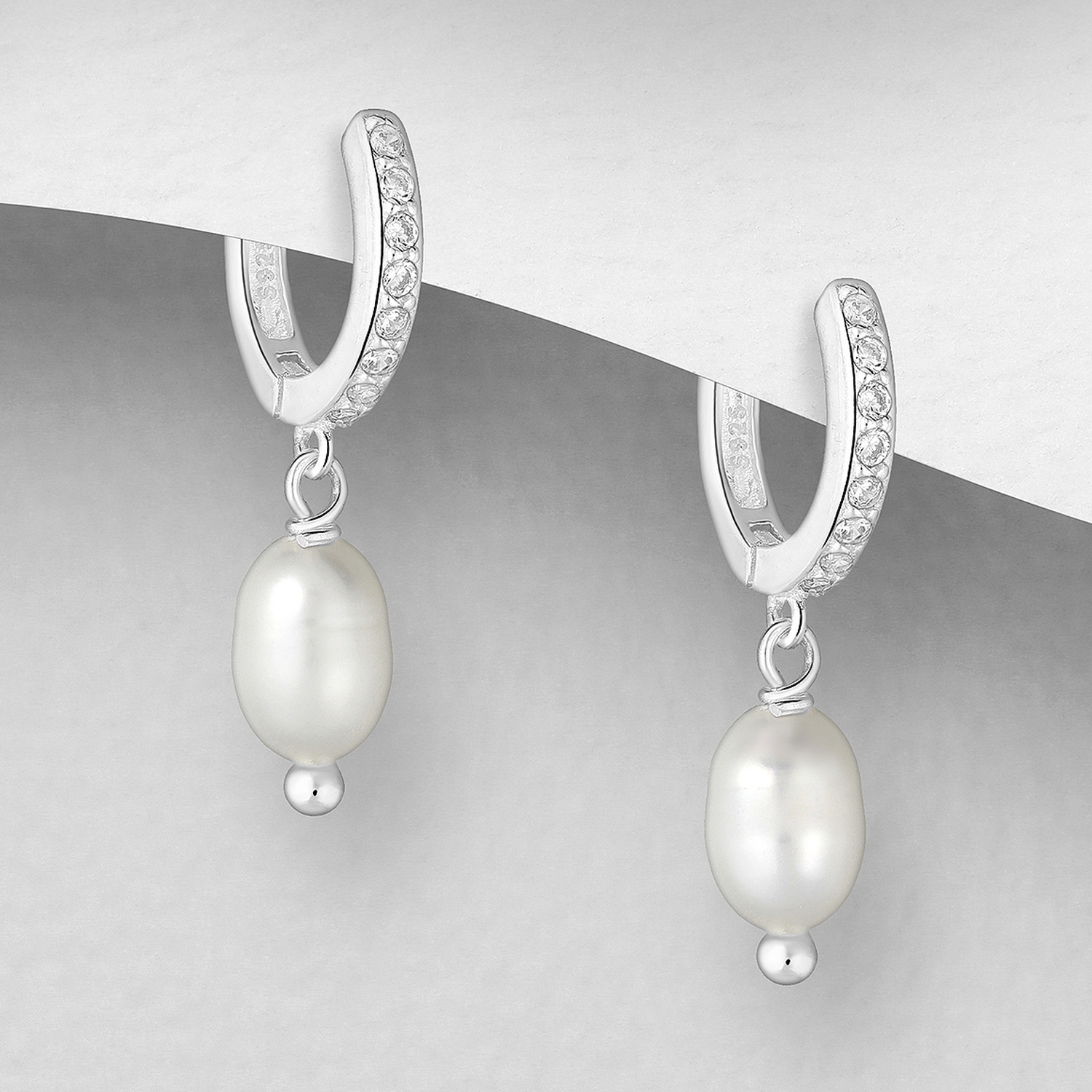 Cubic zirconia hoop earrings with freshwater pearl drop, on a grey display card