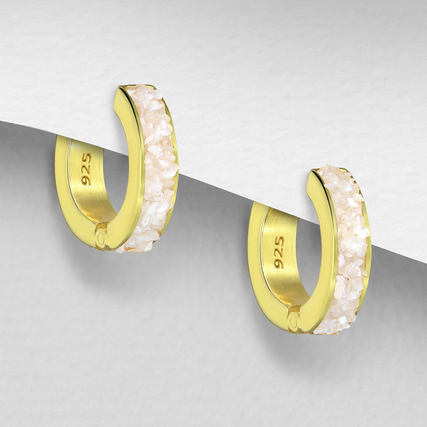 Gold-plated silver huggie hoops with rainbow moonstone, on a grey display card