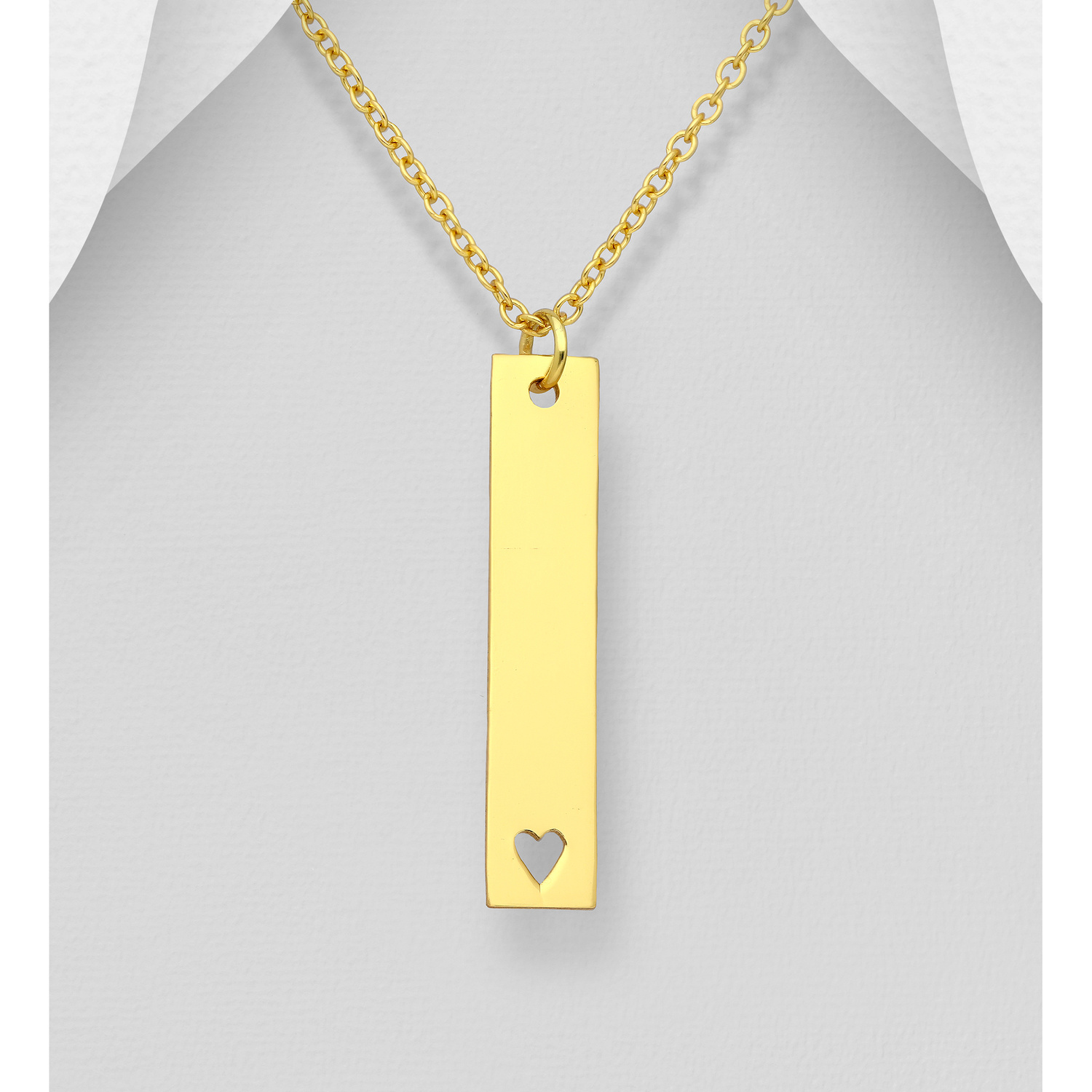 Gold-plated sterling silver bar pendant with a small heart cut-out, shown on a chain against a grey background