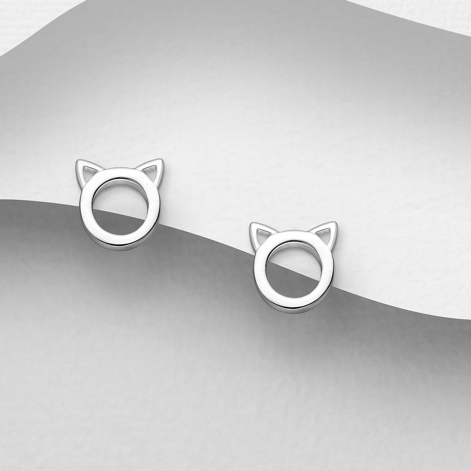 Sterling silver cat ear studs, on a grey display card