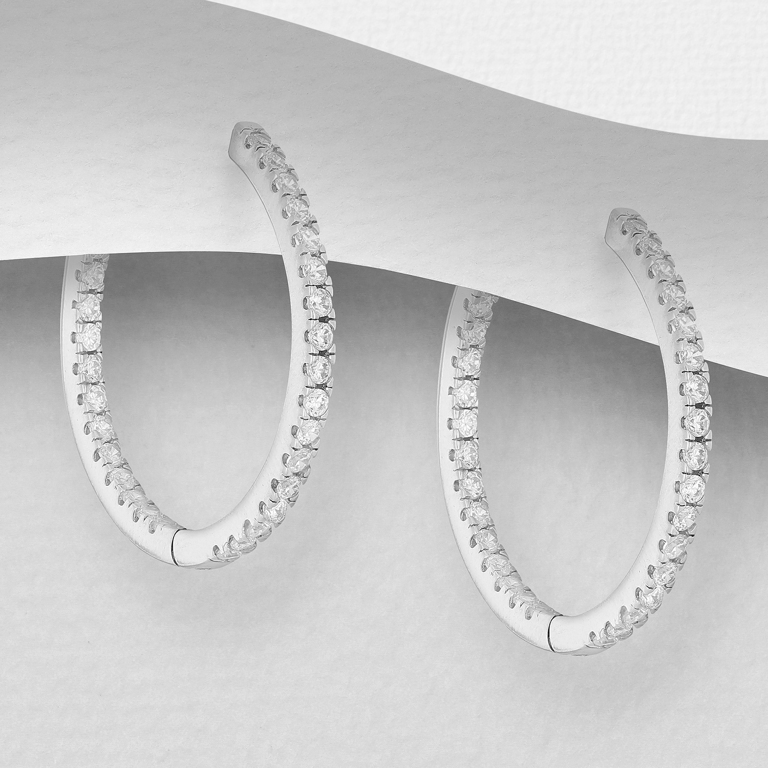Sterling silver hoops with cubic zirconia, on a grey display card
