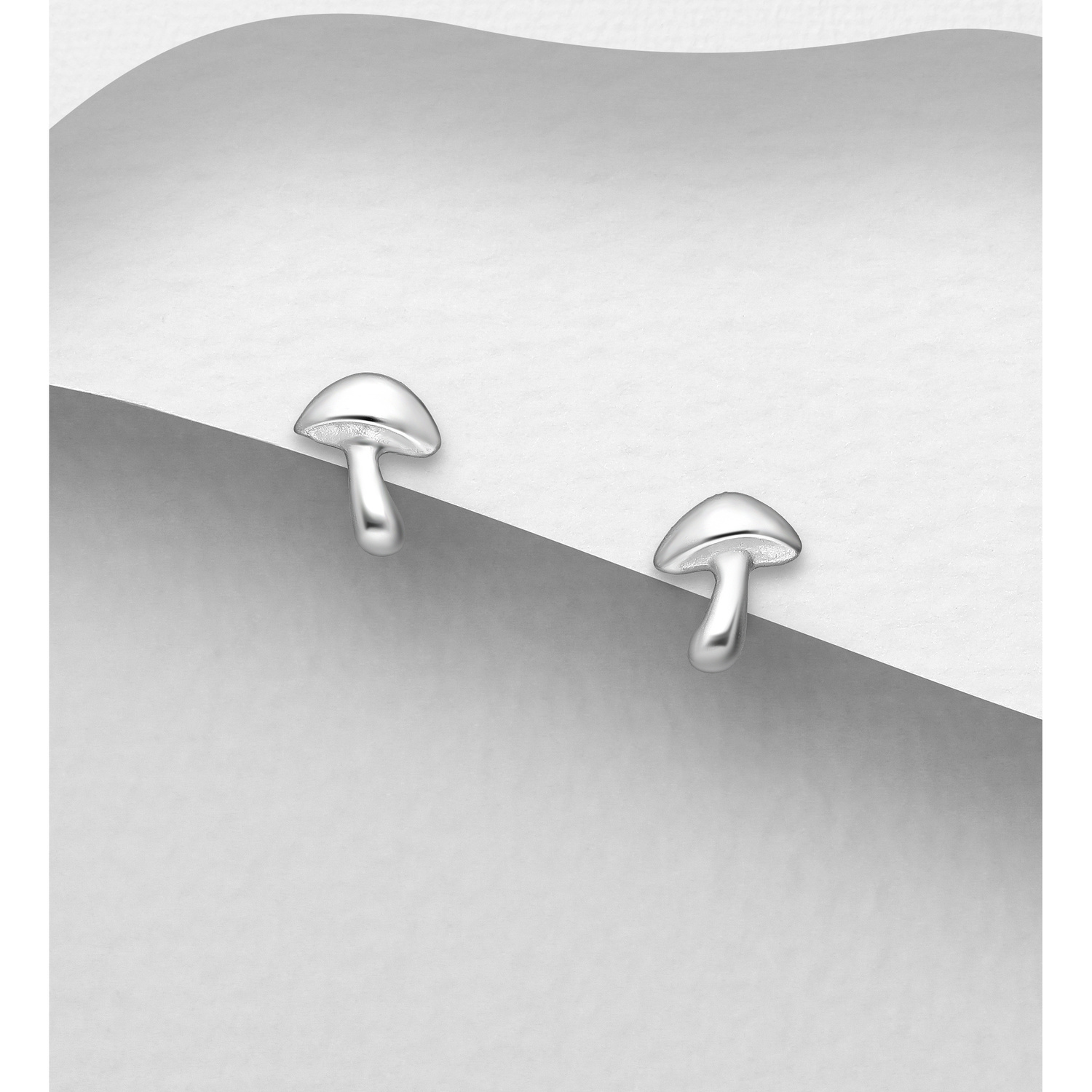 Sterling silver tiny mushroom earrings, on a grey display card